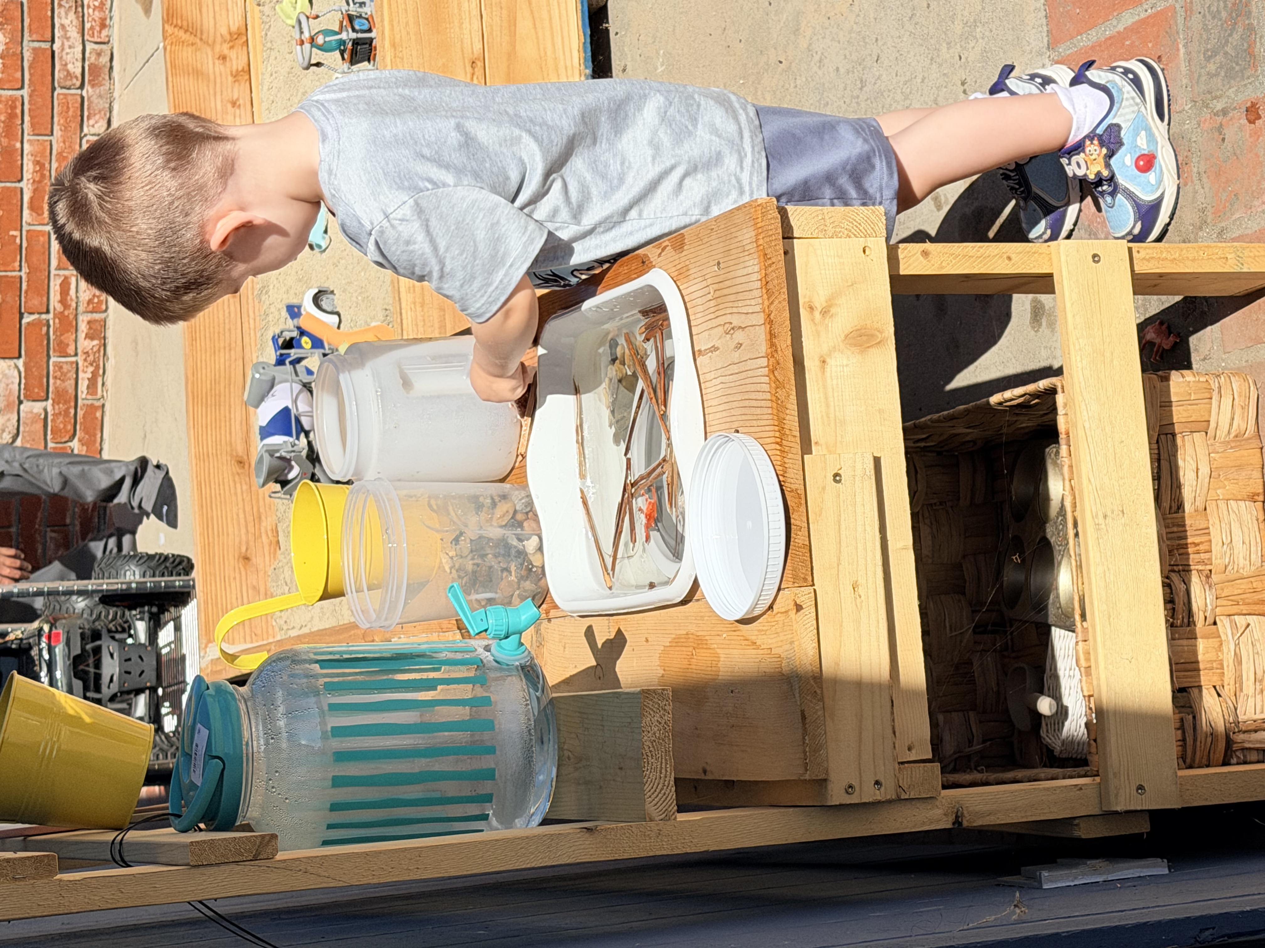 Boy playing at mud kitchen