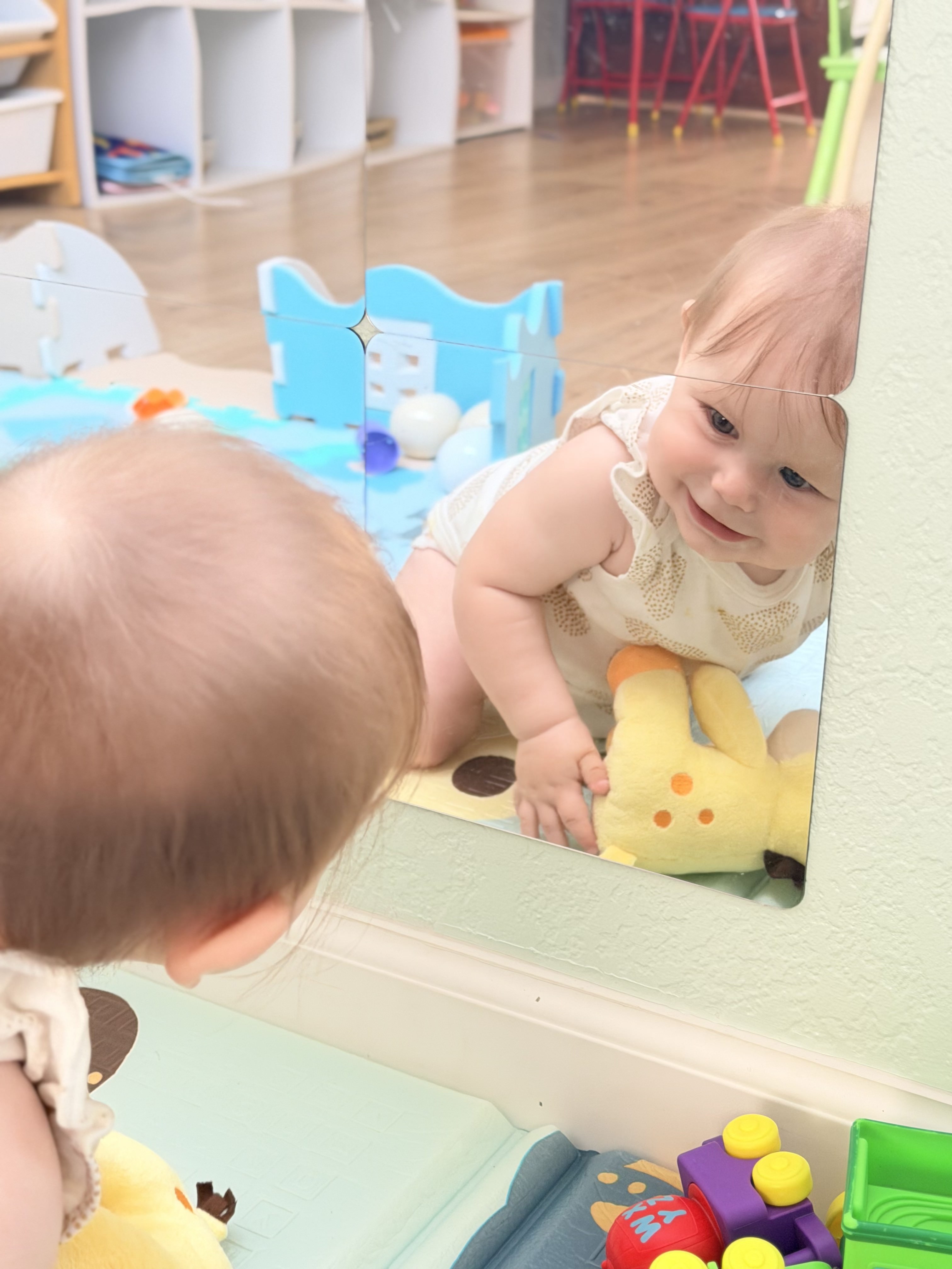 Baby discovering the mirror at Happy Hive